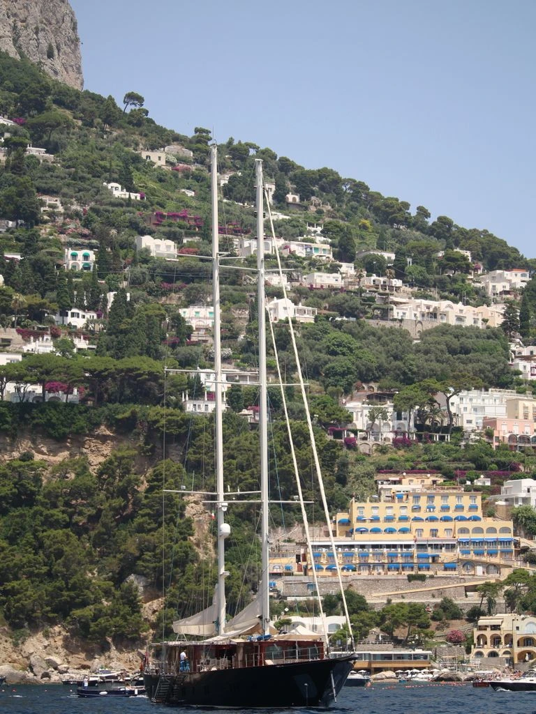 A yacht at anchor in Cala Racó at golden hour